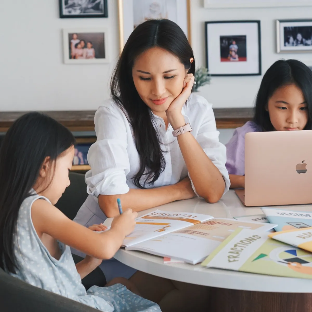 A parent and two children working through GPA workbooks at home