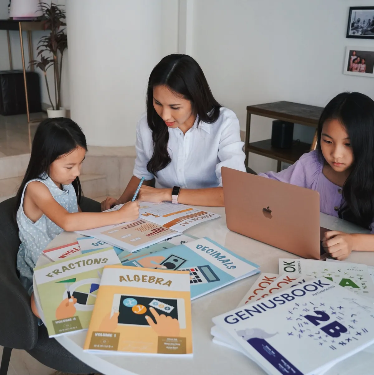 A parent and two children working through GPA workbooks at home