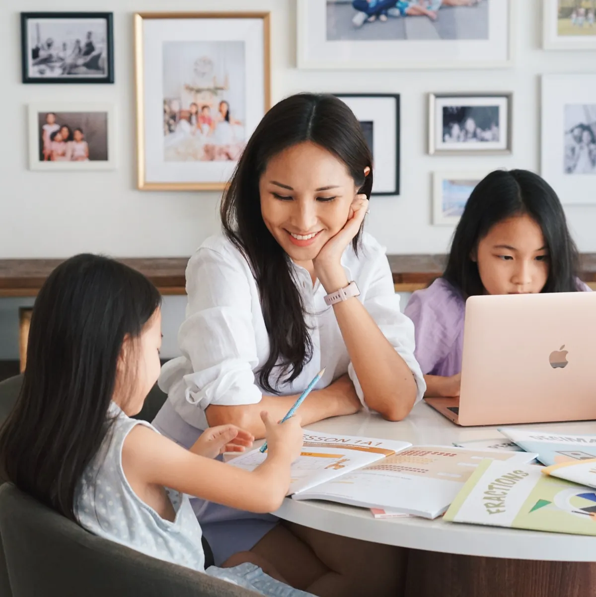 A parent and two children working through GPA workbooks at home